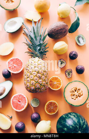 Organic exotic fruit a wallpaper over an orange board, top view,flat lay, ananas circled by watermelon ,mango, passion fruit cantaloupe melon, coconut Stock Photo