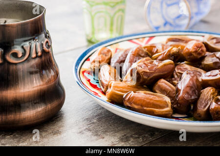 dates food in plate on wooden table Stock Photo