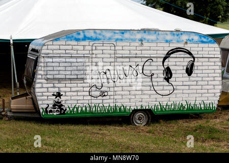 A caravan painted with a brick work design and the word 'music' spiralling from a headphone cord. Stock Photo