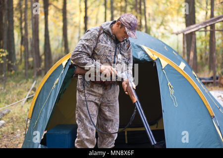 hunter charging his shotgun before hunting in the hunting camp Stock Photo