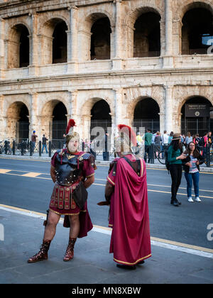 Rome, Italy - 6 May 2018: Two centurions in front of the Colosseum, waiting for some tourists to want to be photographed with them. In the background  Stock Photo