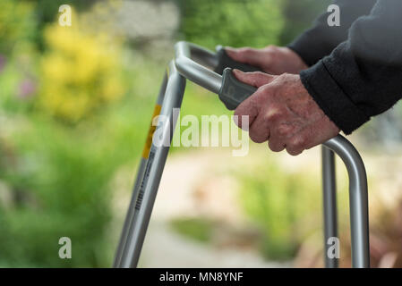 Senior, elderly caucasian man using a walking frame or zimmer mobility aid. Stock Photo