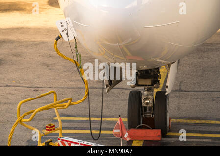 Close up of cables connected to a parked commercial aircraft at an airport in Australia Stock Photo