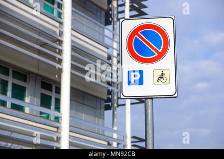 handicapped sign mark parking spot, disabled parking permit sign on pole with convenience store in gas station area background, copy space Stock Photo