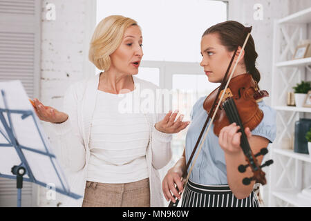Angry girl looking at her tutor Stock Photo