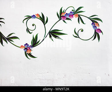 Ibiza Island, Spain - May 02, 2018: Colorful vintage floral ornament on a white wall. Graffiti art on the street of Ibiza. Balearic Islands. Spain Stock Photo