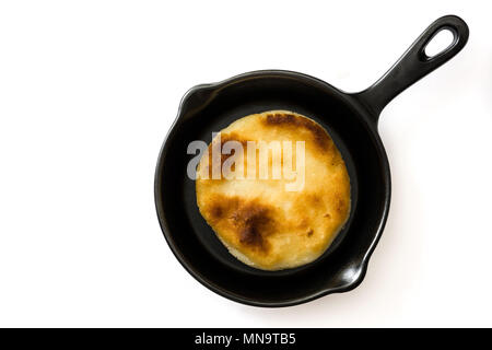 Arepas in frying pan isolated on white background. Venezuelan typical food. Top view. Copyspace Stock Photo
