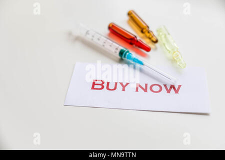 Pills and syringe. Pills and syringe on red background. Copy space.Buy now poster, card. Internet shopping. Advertising Poster design. Medicine in vials and syringe ready for injection. Stock Photo