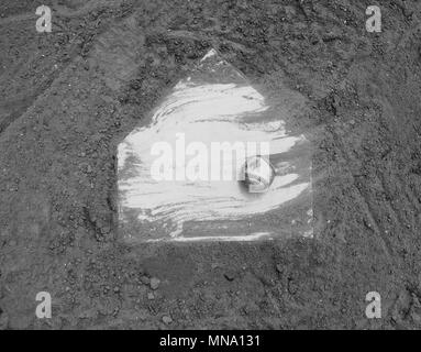 Baseball laying with homeplate on dirt field for game in black and white. Stock Photo