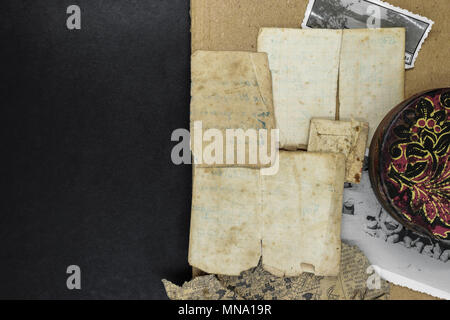 Mix of old and aged document, photo and metal box on black background surface Stock Photo