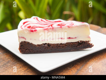 Chocolate brownie with vanilla ice cream and a strawberry swirl Stock Photo
