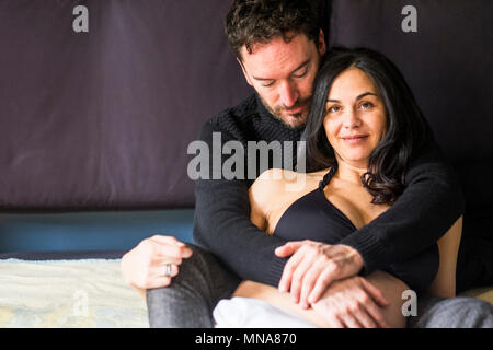 caucasian man and pregnant woman rest on the bed in the wake up morning time scene. smile and happiness for the baby that will arrive to make a new fa Stock Photo
