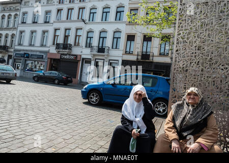 Elderly Muslim women rest on a hot day next to the Molenbeek Market.  Molenbeek is one of 19 districts that make up Brussels, the capital city of Belgium. In recent history Molenbeek has become infamous for being the heart of Islamic extremism in Europe. Per population capita, Molenbeek has produced the largest number of radical Islamists in Europe who have travelled to Syria to fight with ISIS. Stock Photo