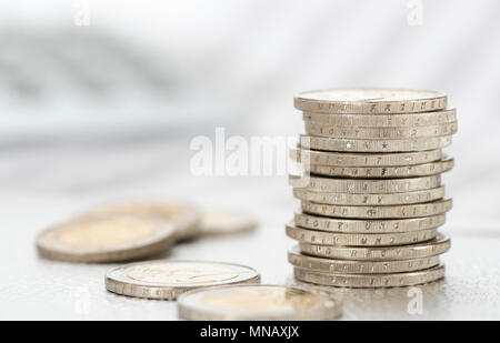 stacked coins of european currency with data of stock market and calculator Stock Photo