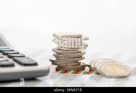 stacked coins of european currency with data of stock market and calculator Stock Photo