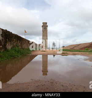 Galle Fort Clock Tower at Galle in Sri Lanka. The tower reflects in a puddle. Stock Photo