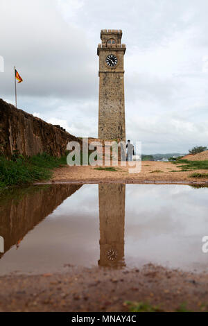 Galle Fort Clock Tower at Galle in Sri Lanka. The tower reflects in a puddle. Stock Photo