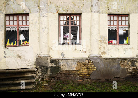 Riga, Latvia. Neglected wall of abandoned house with colorful paintings in windows in Riga. Stock Photo