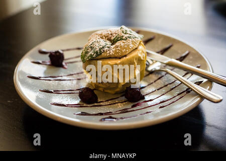 Apple,baked in the oven with honey, nuts and dried fruit.Apple on plate at restaurant.Baked apple with couscous,nuts and dried berries.Fruit dessert baked apple.Warm apple tarte tatin.Toned image Stock Photo