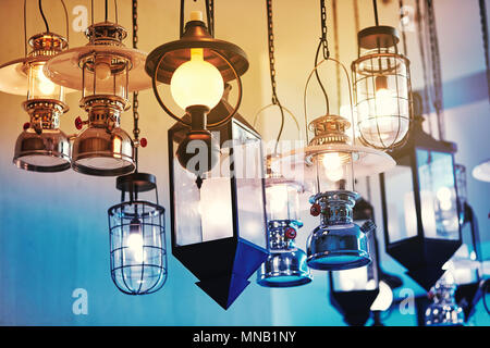 Mixed style of vintage lamp and lantern decorated in the building lights hanging on the ceiling with blue and yellow shading Stock Photo
