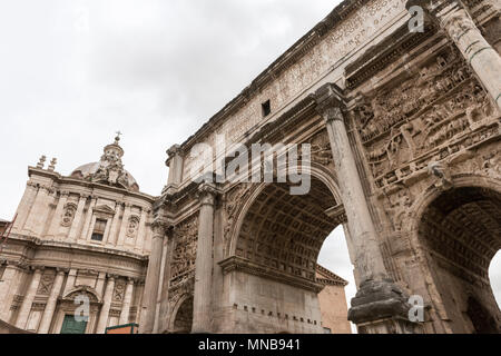 Wide angle picture of the Arch of Titus and church from ancient building from Roman Empire in Rome, Italy Stock Photo