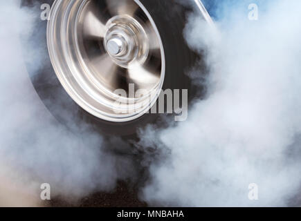 A car doing a burnout so that the tires spin smoke and smell of rubber. Stock Photo