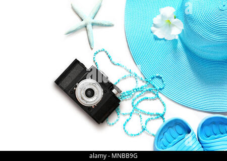 Vintage camera on white surface with beach items, top view. Stock Photo