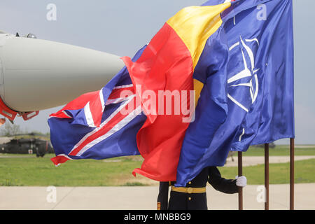 MIHAIL KOGALNICENU, ROMANIA - APRIL 27 A romanian guard can be seen behind NATO, UK and Romania flags, while a Royal Air Force Eurofighter Typhoon Stock Photo