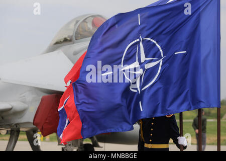 MIHAIL KOGALNICENU, ROMANIA - APRIL 27 A romanian guard can be seen behind NATO, UK and Romania flags, while a Royal Air Force Eurofighter Typhoon Stock Photo
