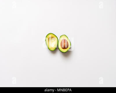 Avocado sliced with seed isolated in white background viewed from above - flatlay look Stock Photo