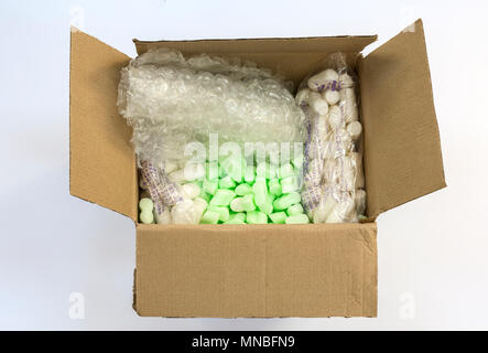 Box with protective packaging - foam chips, bubble wrap, starch foam chips (right and left). Stock Photo