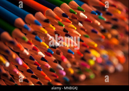 Close-up of multicolored pencils with design elements in rows stacked on each other creating colorful patterns Stock Photo
