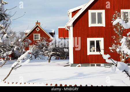 Traditional red Swedish wooden family houses surronded by snow during the winter season Stock Photo