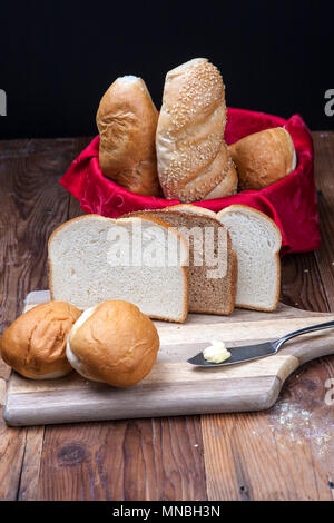 Assorted breads such as sliced bread, rolls, and baguettes on display. Stock Photo
