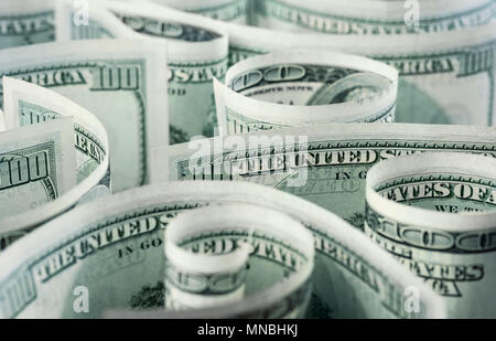 American dollar banknotes rolled, curved in different directions. Money background. Stock Photo