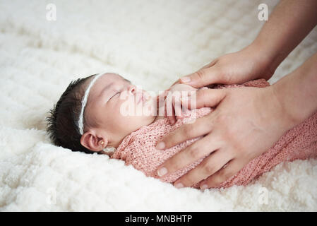 Mom taking care of new born baby on soft white blanket background Stock Photo