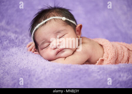 Asian newborn baby close-up portrait on blurred background Stock Photo