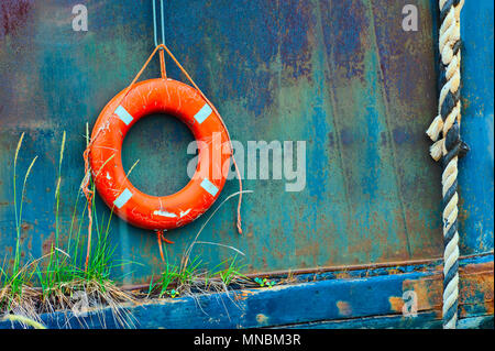 Close up of life perserver rings hanging off an old boat in a field of junk boats in Homer, Alaska.  Seen from a walking path along the Kachemak Bay. Stock Photo