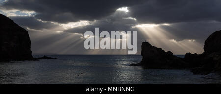 LANZAROTE, CANARY ISLANDS, SPAIN: Rays of sunlight through a cloud on the horizon at Papagayo beach. Stock Photo