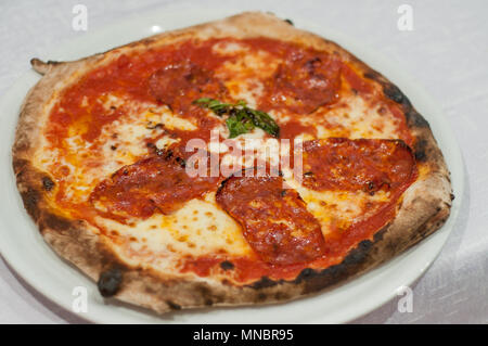 Classic, neapolitan style pizza with spicy salami Stock Photo