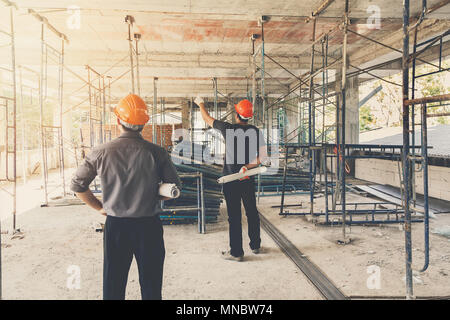 Engineer discussing with foreman about project in building construction site Stock Photo