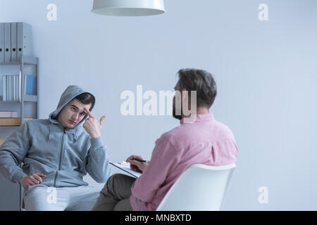 Rebellious teenage boy talking with his psychologist Stock Photo