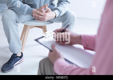 Psychologist taking notes during meeting with his teenage patient Stock Photo