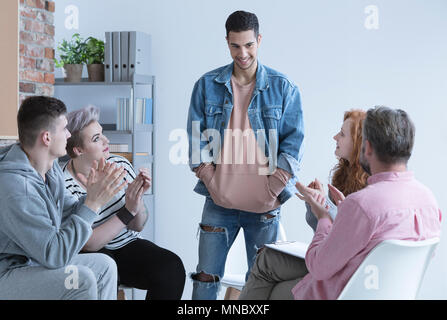Teenage boy talking in front of support group Stock Photo