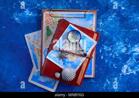 Sea travel and painting concept. Watercolor fantasy map on leather cover captain journals with a magnifying glass on a navy blue background with copy  Stock Photo