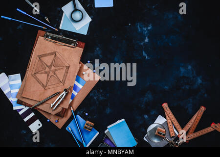 Contractor and architecture concept with craft paper, sketches, compasses, rulers, clipboards and pencils on a dark stone background with copy space. Stock Photo