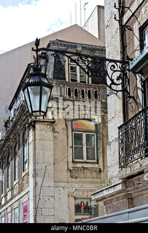 Street lamp mounted on the wall of a downtown building in Lisbon Stock Photo