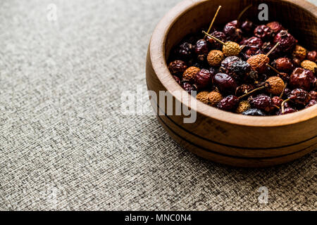 Dried Rosehips in wooden bowl. / kusburnu. Organic Concept. Stock Photo