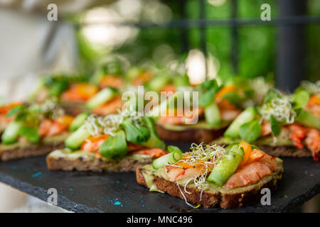 Appetizer canape with shrimp and cucumber on plate on table in the restaurant. close up Stock Photo