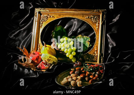 Still life with fresh fruit and dried fruit. Grapes, pomegranate, yellow melon, yellow squash, walnuts, chestnuts. Black background. Golden picture fr Stock Photo